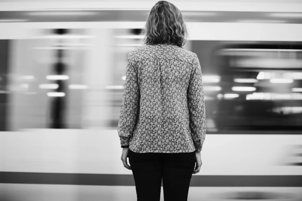 Mulher parada de costas enquanto o mundo ao redor passa acelerado — metáfora do piloto automático e da vida sem presença